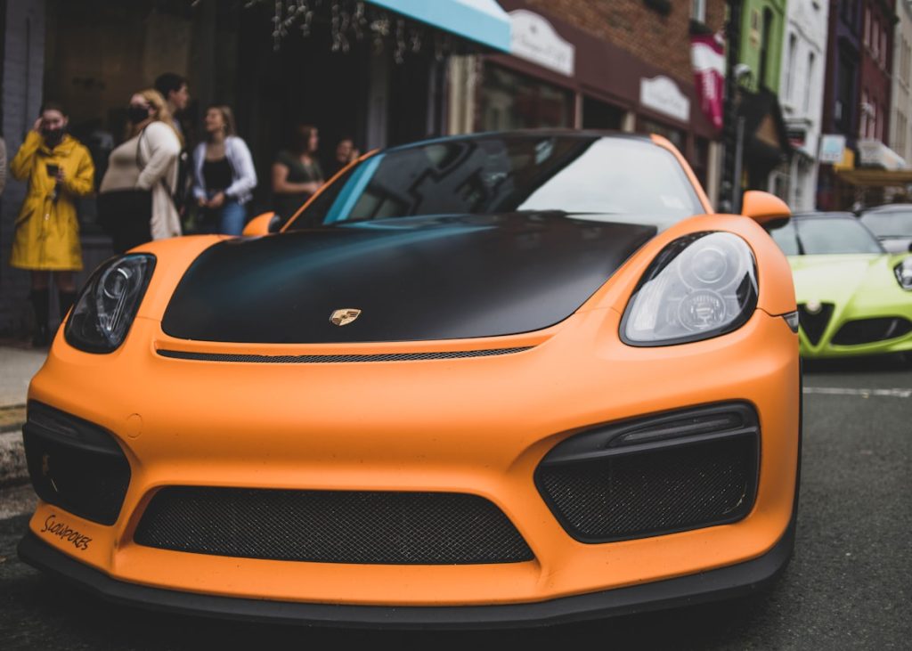 Oranje auto met opvallende vinyl wrap op straat