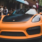 Oranje auto met opvallende vinyl wrap op straat